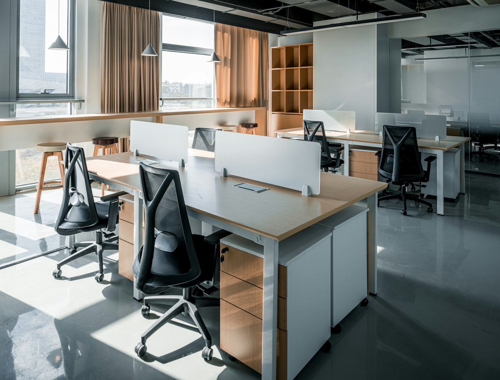 An office with a desk, chairs and a window