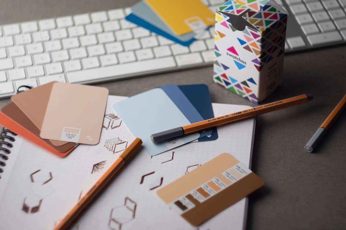 A creative freelancer's desk with keyboard, pencils, and colour swatches