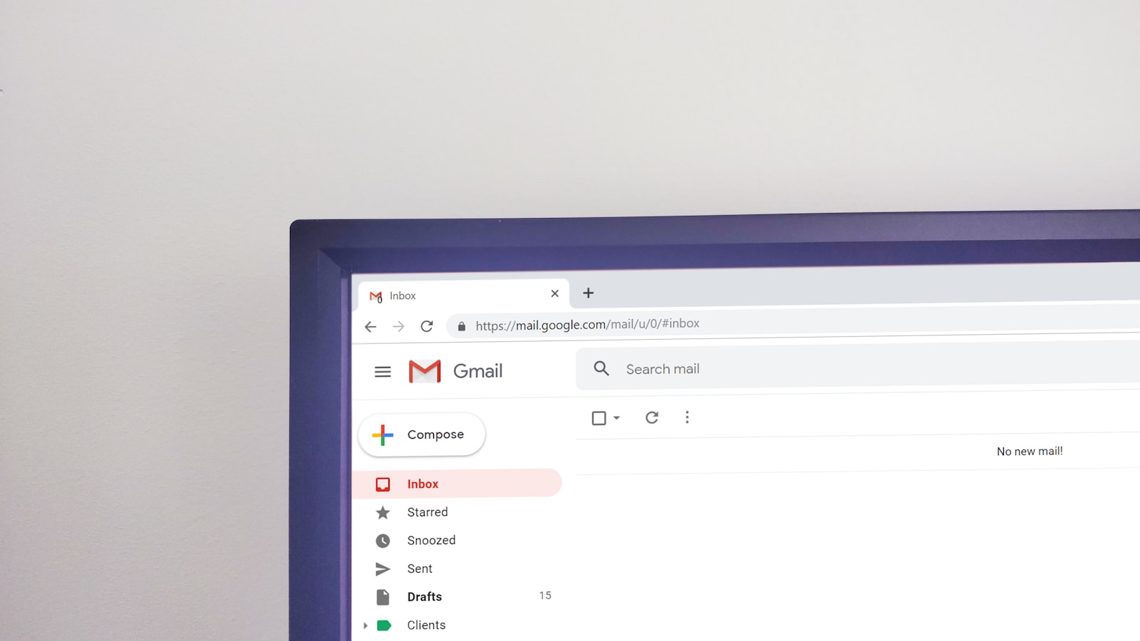 A laptop showing an email inbox on a desk
