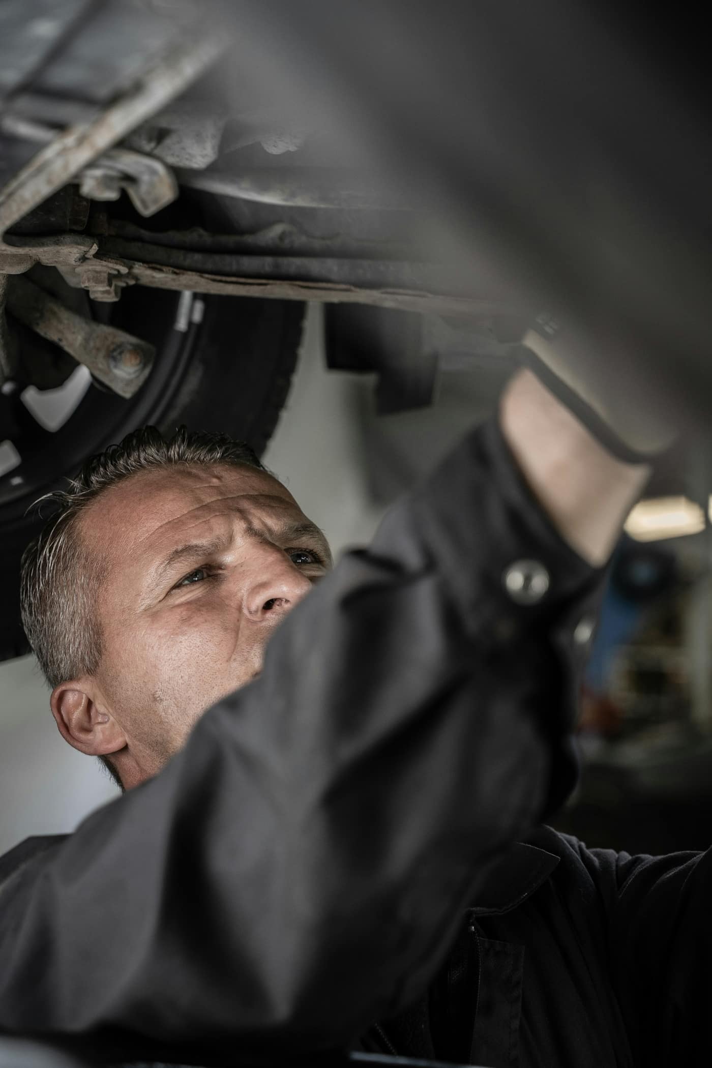 A mechanic working underneath a car