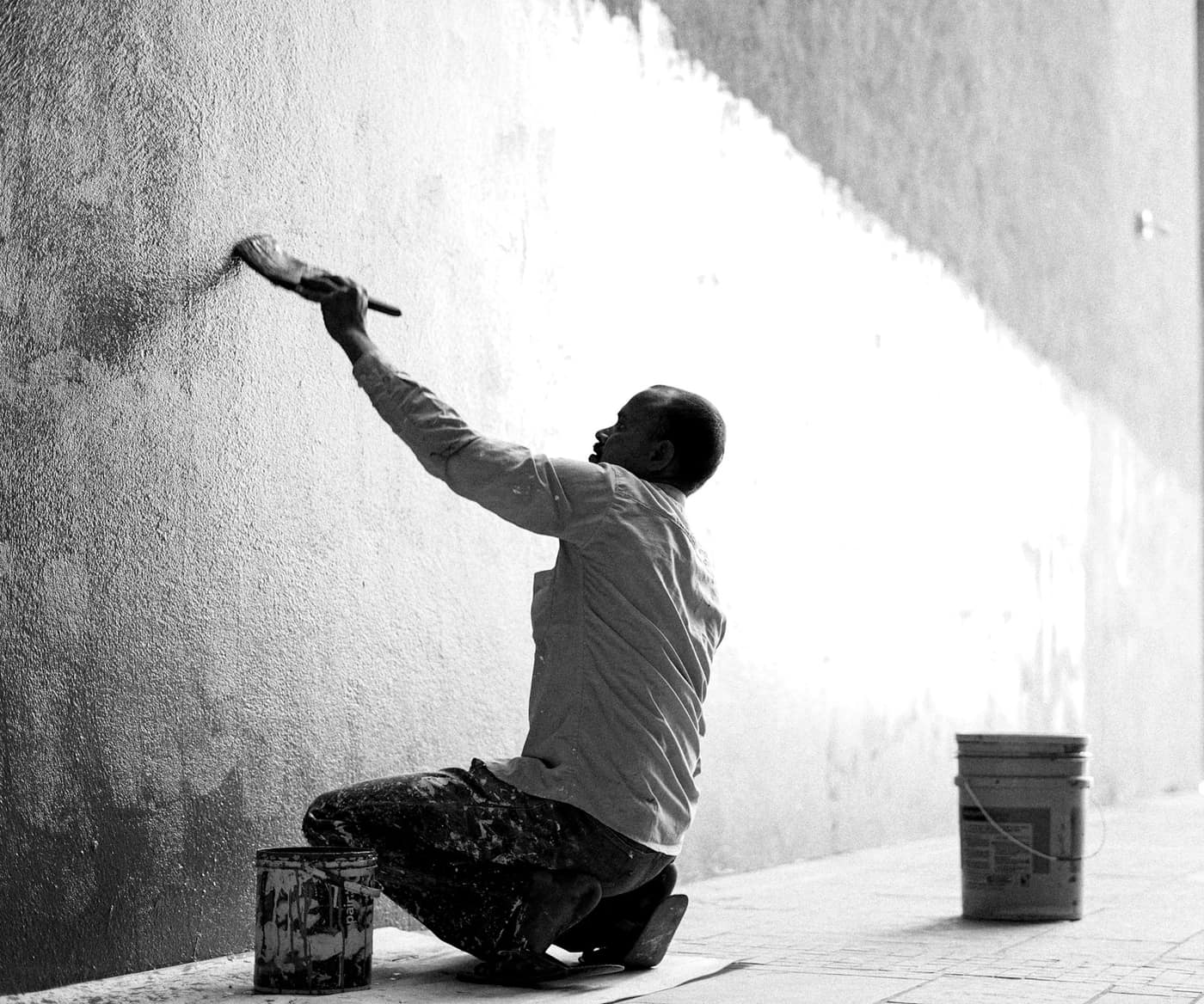 A painter rolling fresh paint onto a wall