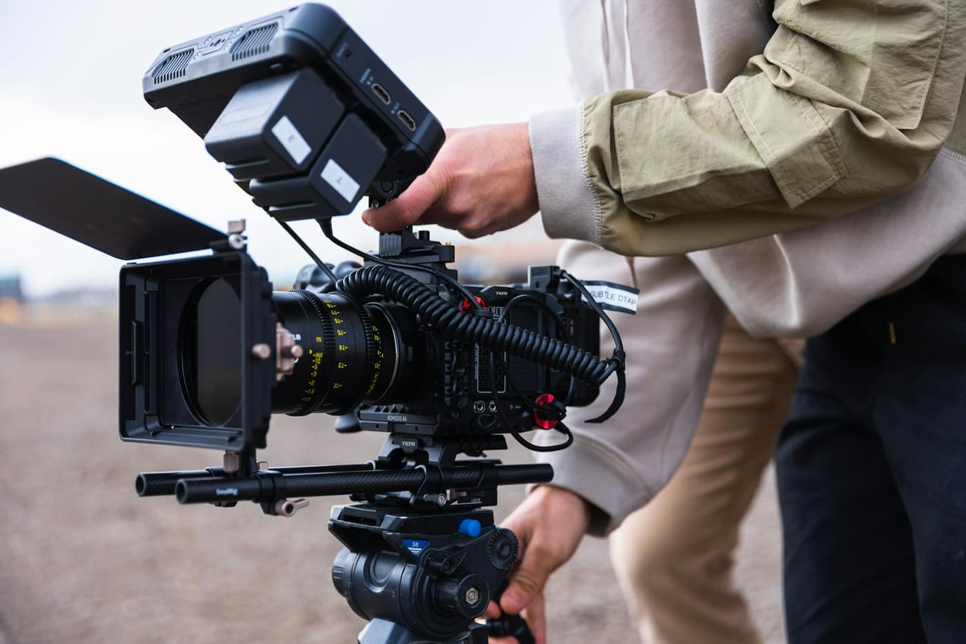 A videographer with a video camera on a tripod