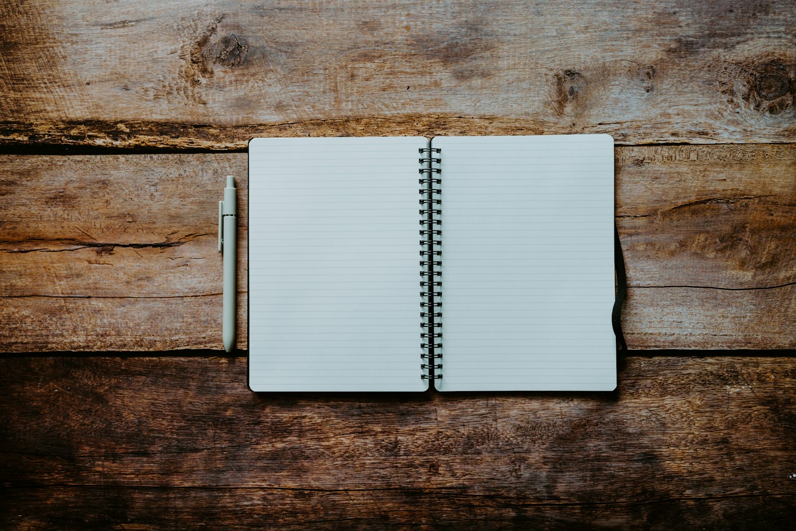 A notebook and pen on a wooden table